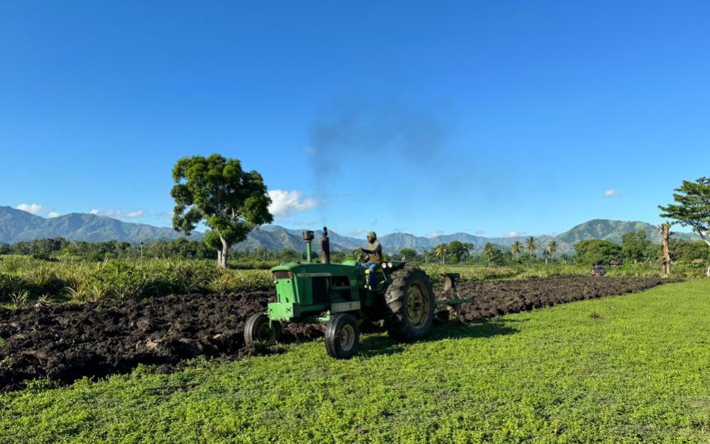 Haitian farmers use tractors to till and work their land faster than they would using a pick axe.