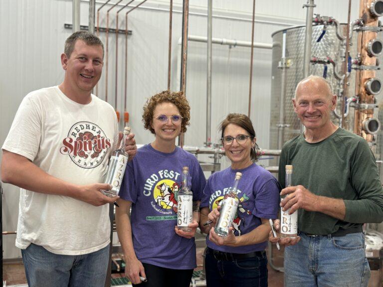 Brother Lucas Sjostrom and his family are standing in their plant holding bottles of one of their products.